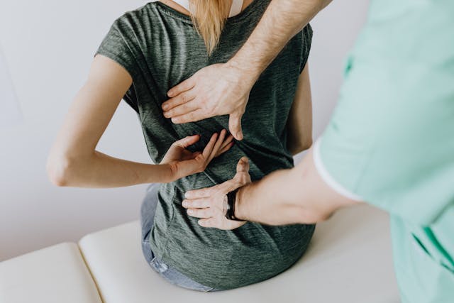 doctor examines woman's back